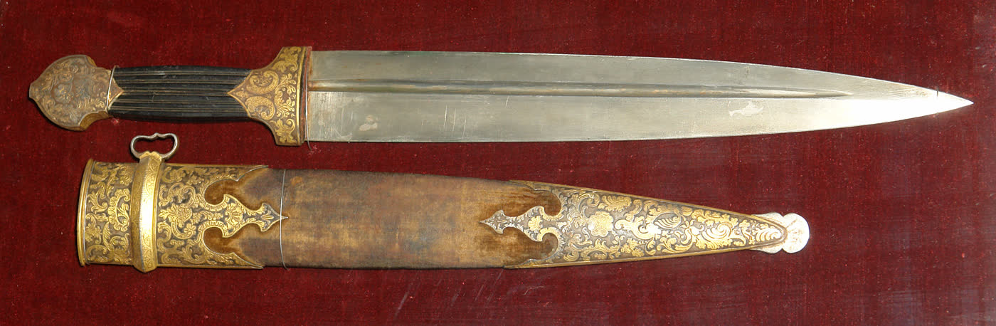 Кинжал из аносовского булата, 1840 год: прямой клинок с долом, рукоять с золочёной насечкой, рядом ножны на красном бархате