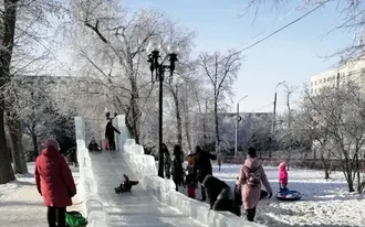 Фотография 2020 года: ледяная горка для детей в Оренбурге, дети съезжают по ледяному жёлобу